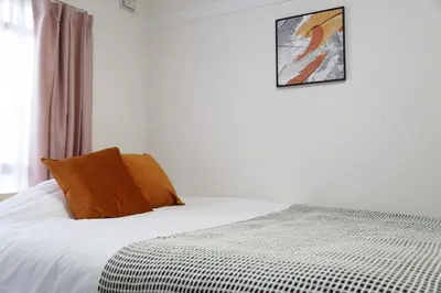 a bedroom with a white bed with a orange pillow at PR204 Shinjuku Perfect location for Kabukichō in Tokyo