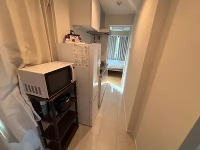 a small kitchen with a microwave and a refrigerator at \u3055\u304f\u3089\u65c5\u9928 \u9ad8\u5186\u5bfa\u5317 \u5343\u5229\u4f11401\u53f7\u5ba4 in Tokyo