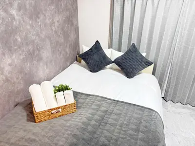 a white bed with pillows and a basket on it at Waseda University area 3F6 with elevator in Tokyo