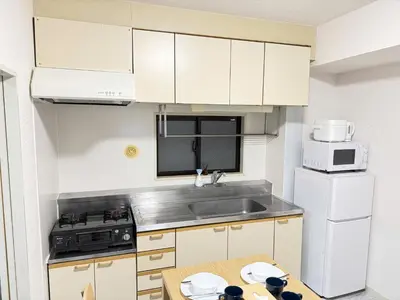 a small kitchen with white cabinets and a table at Waseda University area 3F6 with elevator in Tokyo