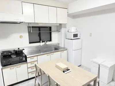 a kitchen with white cabinets and a wooden table at Waseda University area 3F6 with elevator in Tokyo