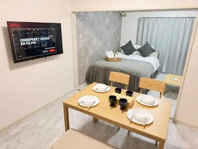 a small room with a bed and a table and chairs at Waseda University area 3F6 with elevator in Tokyo