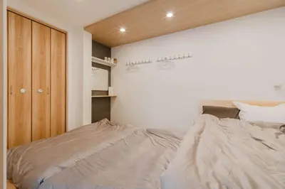 a bedroom with a bed and a wooden cabinet at AMBLE Asakusa in Tokyo