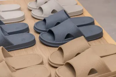a row of different colored flip flops on a table at AMBLE Asakusa in Tokyo