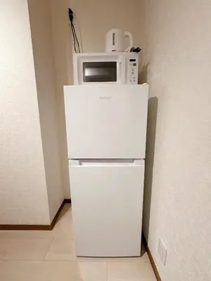 a white microwave sitting on top of a refrigerator at The Travelers Court Bunkyo III in Tokyo