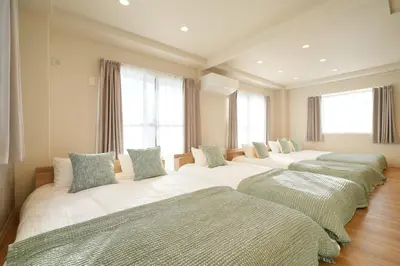 a row of beds in a room with windows at Unite Stay Urayasu201 Close to Disneyland, 15 minutes by bus, 8 minutes by car, and good access from the nearest station to Tokyo Station, Ginza, and Asakusa in Tokyo