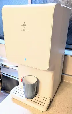 an apple computer with a cup on a stand at Wood River House \u9580\u524d\u4ef2\u753a\u99c5 \u6728\u5834\u99c5 in Tokyo