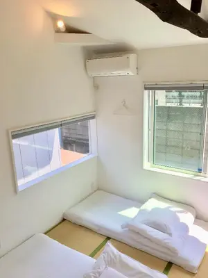 two beds in a room with two windows at Sato-san's Rest in Tokyo