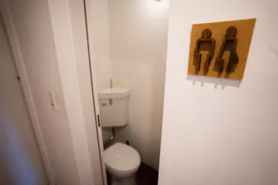 a small bathroom with a toilet and a painting on the wall at Sato-san's Rest in Tokyo