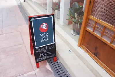 a sign for a sushi restaurant on the side of a building at Sato-san's Rest in Tokyo