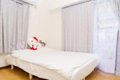 a bedroom with a bed with a stuffed animal on it at \u5466\u5466\u9e7f\u9e23\u6c11\u5bbf302\u4e0a\u91ce\u9644\u8fd1\u5165\u8c37\u4e0a\u91ce\u516c\u56ed\u6b65\u884c\u5708 \u65e5\u6bd4\u8c37\u7ebf jr\u7ebf \u53cc\u7ebf\u53ef\u5229\u7528 in Tokyo