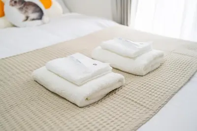 two towels sitting on top of a bed at \u5466\u5466\u9e7f\u9e23\u6c11\u5bbf302\u4e0a\u91ce\u9644\u8fd1\u5165\u8c37\u4e0a\u91ce\u516c\u56ed\u6b65\u884c\u5708 \u65e5\u6bd4\u8c37\u7ebf jr\u7ebf \u53cc\u7ebf\u53ef\u5229\u7528 in Tokyo