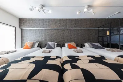a room with three beds in a room at WASABI Shibuya in Tokyo