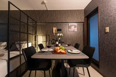 a dining room with a table and chairs and a bed at WASABI Shibuya in Tokyo