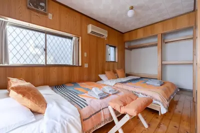 two beds in a room with wooden walls at NOKA stay MIZUE - \u30aa\u30fc\u30d7\u30f3\u7279\u5225\u4fa1\u683c, \u6700\u59276\u540d\u8cb8\u5207, \u6d45\u8349 \u6771\u4eac \u9280\u5ea7 \u4e0a\u91ce 30\u5206, \u30c7\u30a3\u30ba\u30cb\u30fc \u65b0\u5bbf \u6e0b\u8c3740\u5206 in Tokyo
