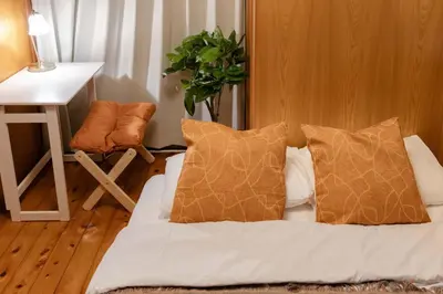 a bedroom with a bed with pillows and a desk at NOKA stay MIZUE - \u30aa\u30fc\u30d7\u30f3\u7279\u5225\u4fa1\u683c, \u6700\u59276\u540d\u8cb8\u5207, \u6d45\u8349 \u6771\u4eac \u9280\u5ea7 \u4e0a\u91ce 30\u5206, \u30c7\u30a3\u30ba\u30cb\u30fc \u65b0\u5bbf \u6e0b\u8c3740\u5206 in Tokyo