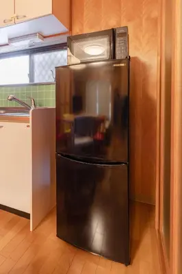 a microwave sitting on top of a refrigerator in a kitchen at NOKA stay MIZUE - \u30aa\u30fc\u30d7\u30f3\u7279\u5225\u4fa1\u683c, \u6700\u59276\u540d\u8cb8\u5207, \u6d45\u8349 \u6771\u4eac \u9280\u5ea7 \u4e0a\u91ce 30\u5206, \u30c7\u30a3\u30ba\u30cb\u30fc \u65b0\u5bbf \u6e0b\u8c3740\u5206 in Tokyo