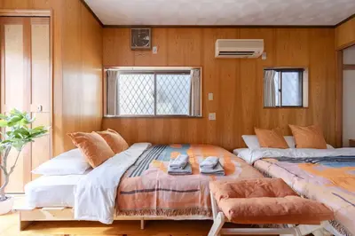 two beds in a room with wooden walls at NOKA stay MIZUE - \u30aa\u30fc\u30d7\u30f3\u7279\u5225\u4fa1\u683c, \u6700\u59276\u540d\u8cb8\u5207, \u6d45\u8349 \u6771\u4eac \u9280\u5ea7 \u4e0a\u91ce 30\u5206, \u30c7\u30a3\u30ba\u30cb\u30fc \u65b0\u5bbf \u6e0b\u8c3740\u5206 in Tokyo