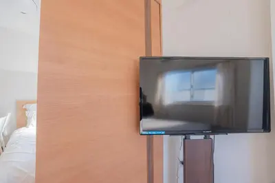 a flat screen tv hanging on a wall at \u65b0\u5bbf\u99c5\u30a8\u30ea\u30a2\u5f92\u6b69\u570f \u4ea4\u901a\u81f3\u4fbf \u89b3\u5149 \u30b7\u30e7\u30c3\u30d4\u30f3\u30b0 \u30b0\u30eb\u30e1\u306b\u6700\u9069\u306a\u5317\u65b0\u5bbf\u30b9\u30c6\u30a4 So1g in Tokyo