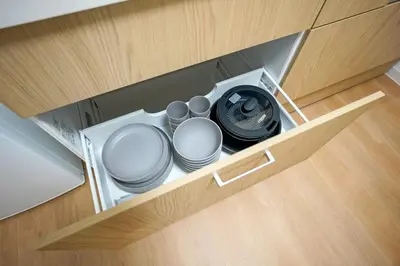 an open drawer with plates and a dishwasher at BT House Bentencho Shinjuku Waseda in Tokyo