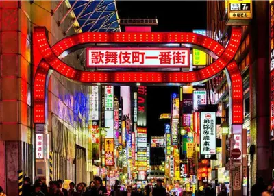 a busy city street at night with neon signs at \u7f8e-yahiro- in Tokyo