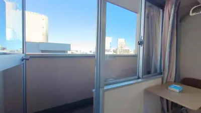 a window in a room with a view of a city at Ikebukuro center#\u6c60\u888b\u4e2d\u5fc3#\u9ad8\u7ea7\u9633\u5149\u516c\u5bd3\u8f66\u7ad9\u6b65\u884c5\u5206#\u9ad8\u901fwifi1208 in Tokyo