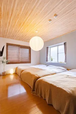 two beds in a bedroom with a wooden ceiling at Maison Shin Nakano 201 MS21 in Tokyo