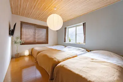 two beds in a room with a ceiling at Maison Shin Nakano 201 MS21 in Tokyo