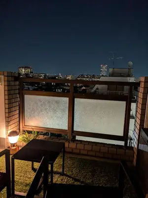 a balcony with three windows with a view of a city at Nuan Stay Tokyo in Tokyo