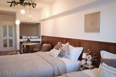 a hotel room with two beds and a dining room at Nuan Stay Tokyo in Tokyo