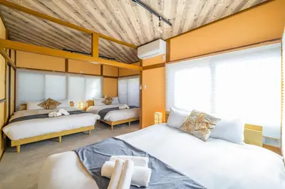 a bedroom with two beds and two windows at Chill Place 124 Horikiri Shobuen in Tokyo