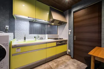 a yellow kitchen with a sink and a stove at Chill Place 124 Horikiri Shobuen in Tokyo