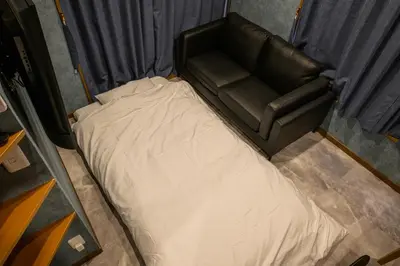 a black leather couch sitting in a small room at Chill Place 124 Horikiri Shobuen in Tokyo