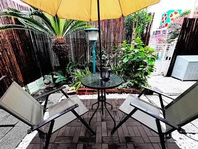 a patio with a table and two chairs and an umbrella at Shibuya 10 min Walk Theater & Garden Stay Max 6ppl in Tokyo