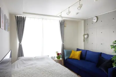 a bedroom with a blue couch and a window at 306 5 mins train to Roppongi , direct bus to Shibuya in Tokyo