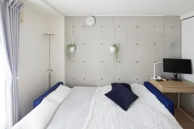 a bedroom with a bed and a clock on the wall at 306 5 mins train to Roppongi , direct bus to Shibuya in Tokyo