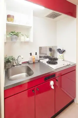 a kitchen with red cabinets and a sink at 306 5 mins train to Roppongi , direct bus to Shibuya in Tokyo