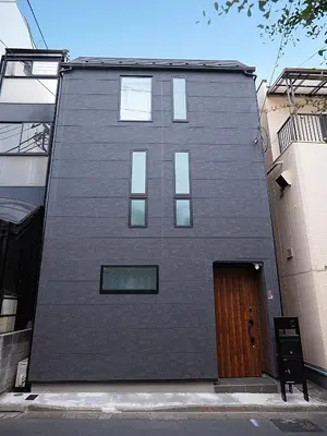 a black building with a wooden door on a street at \u685c\u306e\u5ddd76 \u6c60\u888b\u99c5C6\u53e3 8\u5206 2-10\u4eba\u4e28Ikebukuro JR Line C6 Exit 8 minutes 2-10 people in Tokyo