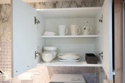 a white cupboard with plates and dishes in it at VillaŌyama 111 in Tokyo