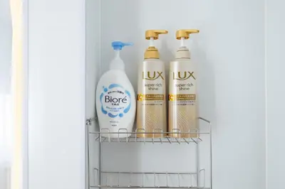 three bottles of detergent sitting on a shelf in a refrigerator at VillaŌyama 111 in Tokyo