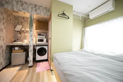 a bedroom with a washer and dryer in a room at VillaŌyama 111 in Tokyo