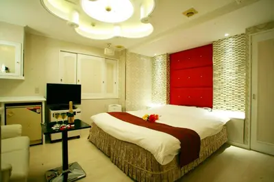 a bedroom with a large bed with a red wall at \u30db\u30c6\u30eb \u30b0\u30ea\u30fc\u30f3\u30d2\u30ebAdult only in Tokyo