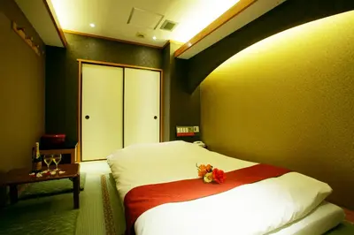 a bedroom with a bed with a flower on it at \u30db\u30c6\u30eb \u30b0\u30ea\u30fc\u30f3\u30d2\u30ebAdult only in Tokyo