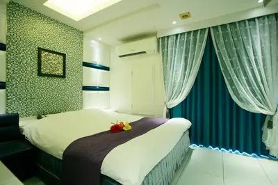 a bedroom with a bed with blue and white curtains at \u30db\u30c6\u30eb \u30b0\u30ea\u30fc\u30f3\u30d2\u30ebAdult only in Tokyo