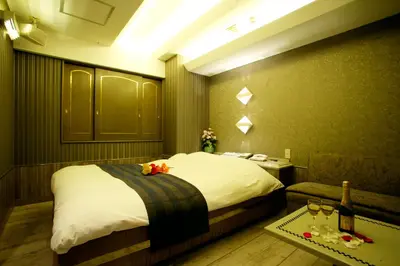 a hotel room with a bed and a table with wine glasses at \u30db\u30c6\u30eb \u30b0\u30ea\u30fc\u30f3\u30d2\u30ebAdult only in Tokyo