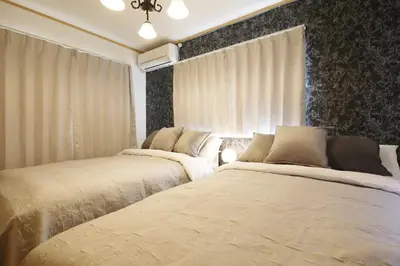 two beds in a bedroom with curtains at Cozy house Tokyo in Tokyo