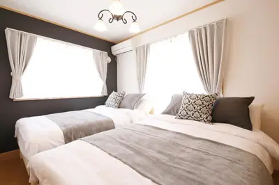two beds in a room with two windows at Cozy house Tokyo in Tokyo