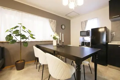 a dining room with a black table and white chairs at Cozy house Tokyo in Tokyo