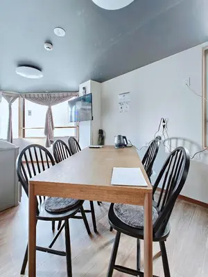 a dining room with a wooden table and chairs at Hamanoya Main in Tokyo