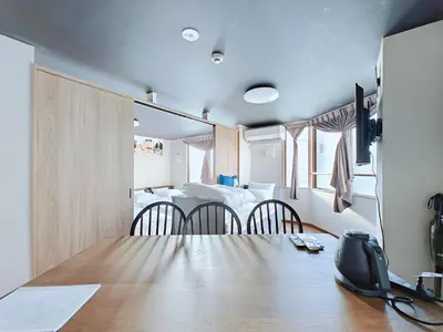 a room with a table and chairs and a bed at Hamanoya Main in Tokyo